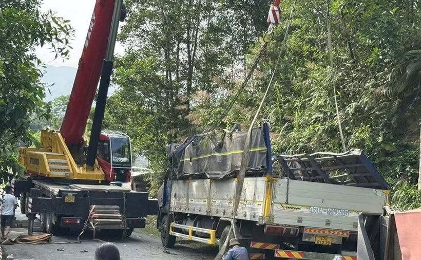 Lực lượng chức năng tổ chức cứu hộ chiếc xe tải bị lật, điều tra nguyên nhân vụ tai nạn. (Ảnh: TTXVN)