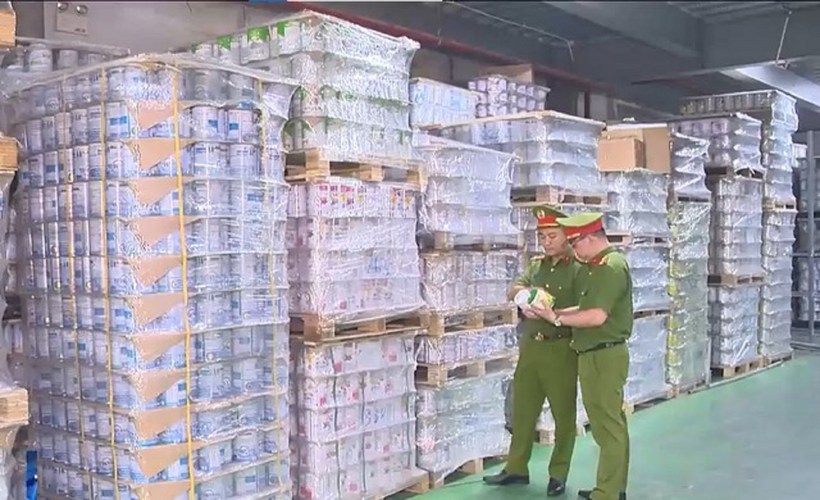 Lực lượng chức năng kiểm tra kho hàng trong đường dây sản xuất 573 loại sữa bột giả. Ảnh: VTV