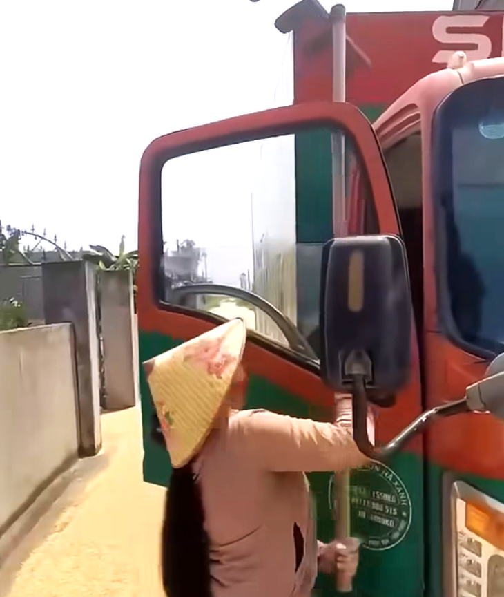 Người phụ nữ cầm cào đòi tấn công tài xế xe tải. (Ảnh: Tuổi trẻ)