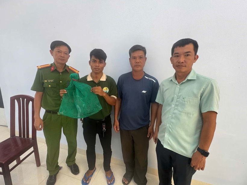 Người dân giao nộp cá thể kỳ đà hoa phát hiện giữa đường cho cơ quan chức năng. Ảnh: Lao động