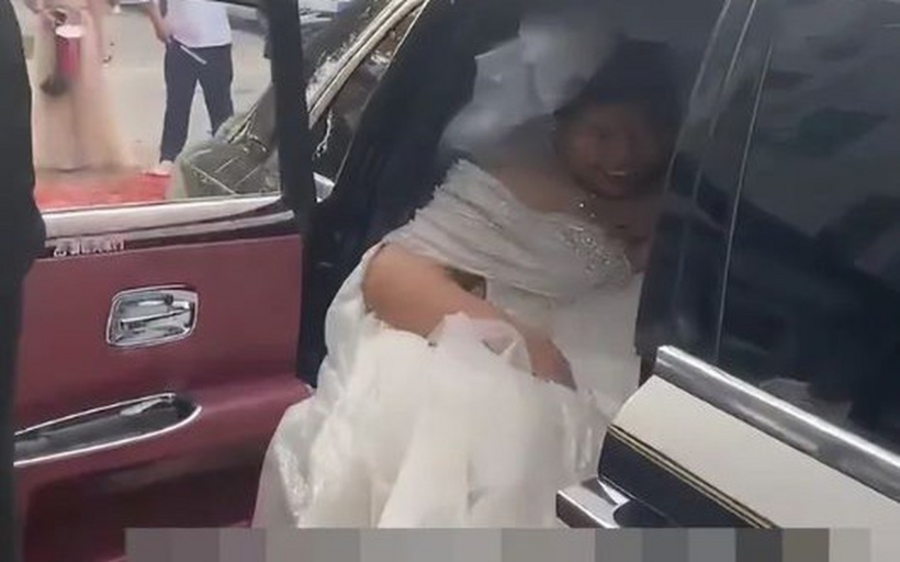 Cô dâu định bước xuống thì một phù dâu lập tức ngăn lại, nhắc rằng theo phong tục, cô dâu phải được chú rể bế hoặc cõng vào nhà.