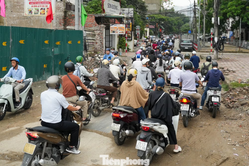 Các phương tiện được hướng dẫn di chuyển vào phố Nguyên Hồng để tránh khu vực đang thi công dự án Vành đai 1 đoạn Hoàng Cầu - Voi Phục. Ảnh: Tiền phong