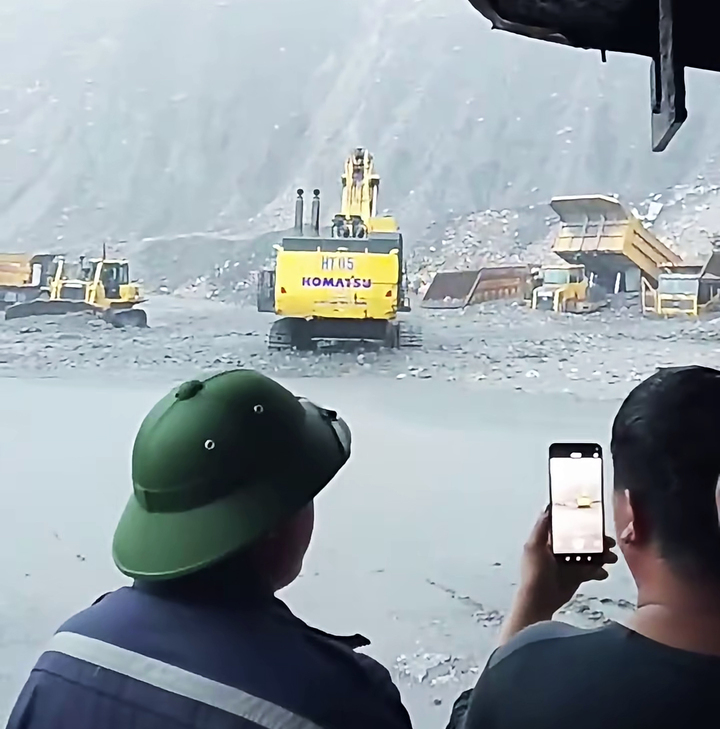 Mưa lớn cuốn trôi đất đá khiến xe tải chuyên chở than tại khai trường Công ty than Hà Tu bị mắc kẹt, đơn vị này phải huy động máy xúc giải cứu. (Ảnh: VTC News)