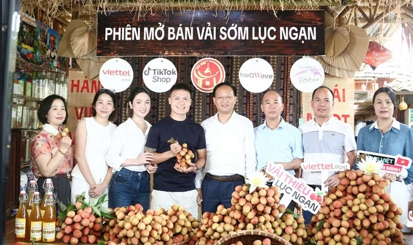Phó Chủ tịch UBND tỉnh Bắc Ninh Phạm Văn Thịnh (ở giữa) và cầu thủ Nguyễn Quang Hải livestream bán vải thiều./ Theo Tiền phong