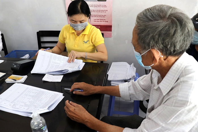 Người dân nhận tiền trợ cấp hằng tháng tại một điểm chi trả. Ảnh minh họa