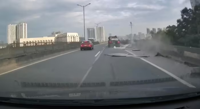 Hàng chục tấm tôn bay từ xe đầu kéo xuống đường Vành đai 3 trên cao.
