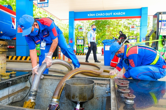 Nhân viên nhập xăng E10 vào bồn chứa tại một cửa hàng xăng dầu. Ảnh:&nbsp;PVOIL