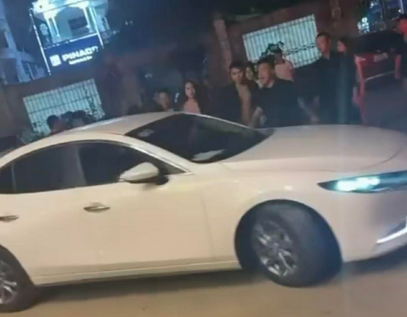 Tài xế lái ô tô cán qua chân người đàn ông đứng giữa đường. Ảnh cắt từ clip/VietNamNet
