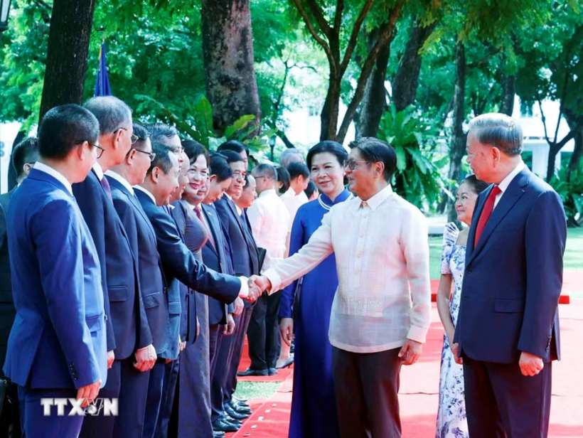 Tổng Bí thư, Chủ tịch nước Tô Lâm giới thiệu với Tổng thống Philippines Ferdinand Romualdez Marcos Jr. và Phu nhân thành viên đoàn cấp cao Việt Nam dự Lễ đón - Ảnh: TTXVN
