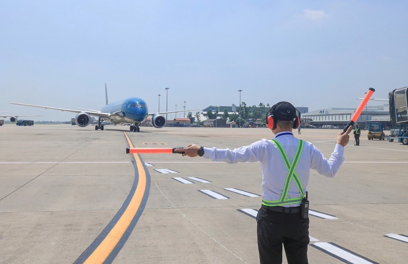 Nhân viên đánh tín hiệu tàu bay thực hiện nhiệm vụ trên sân đỗ Cảng Hàng không quốc tế Nội Bài trong điều kiện thời tiết nắng nóng