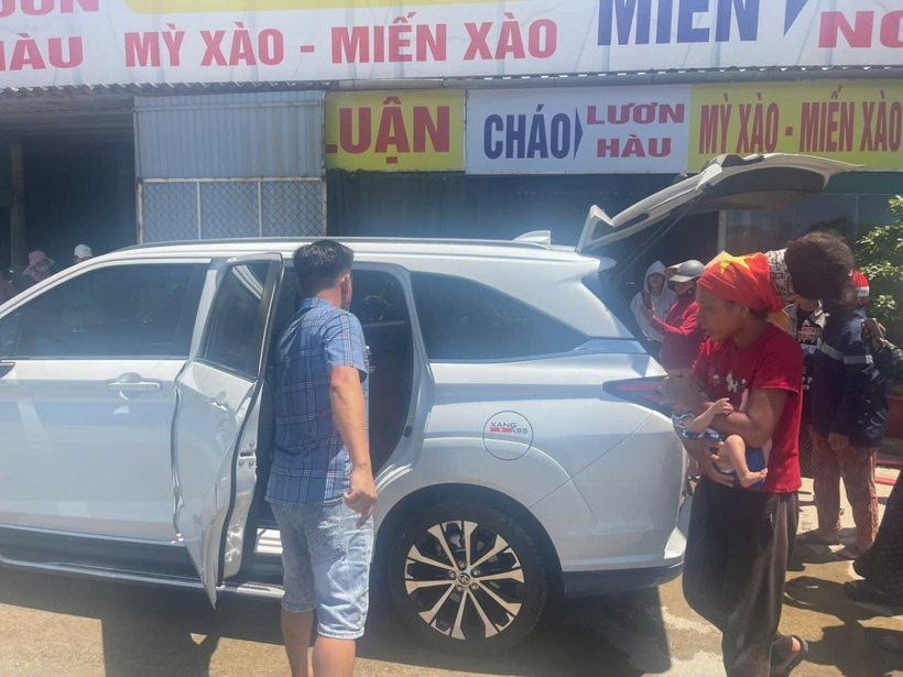 Người phụ nữ cùng hai con nhỏ lên taxi trở về Hà Nội khi đến địa bàn xã Sen Ngư, tỉnh Quảng Trị. Ảnh: Vietnamnet