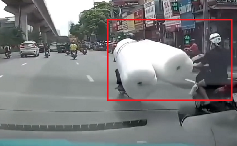 Hình ảnh cắt từ clip thấy rõ hàng cồng kềnh va vào người phụ nữ đi xe máy gây ra vụ tai nạn.