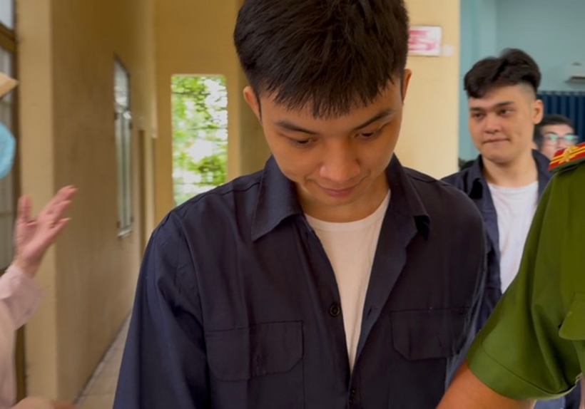 TikToker "Nguyễn Cao Nhật Hoàng" được lực lượng chức năng áp giải rời phòng xử án. Ảnh: Thanh Niên