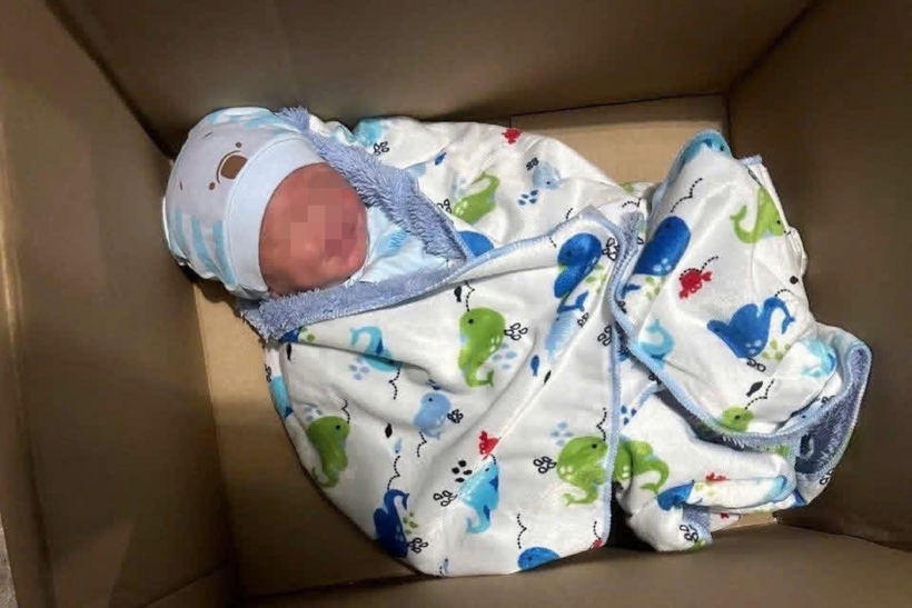Trẻ sơ sinh đặt trong thùng giấy và bỏ trước nhà dân ở phường Tân Đông Hiệp. (Ảnh: Công an phường Tân Đông Hiệp)