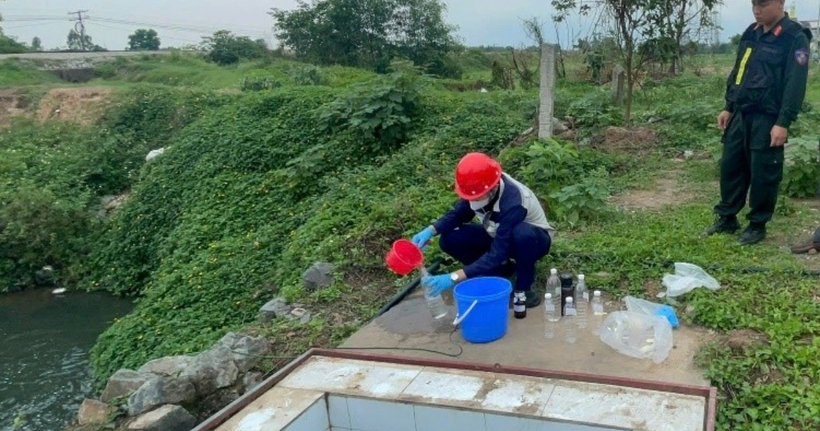 Lực lượng chức năng kiểm tra mẫu nước thải.