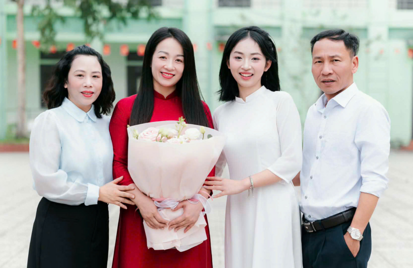 Hương bên cô chủ nhiệm (áo dài đỏ) và bố mẹ. Ảnh: VnExpress