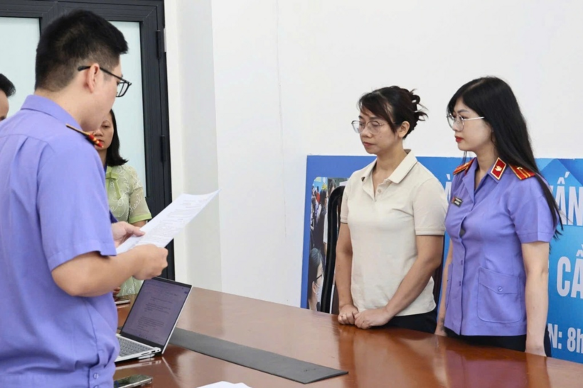 Cơ quan tố tụng tống đạt lệnh khởi tố, bắt tạm giam đối với Lê Thị Hồng Nhung (áo trắng) (Ảnh: Dân trí)