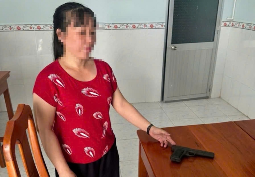 Chị T. nộp súng phát hiện trong tủ quần áo của cha. (Ảnh: Công an phường Mỹ Thới)
