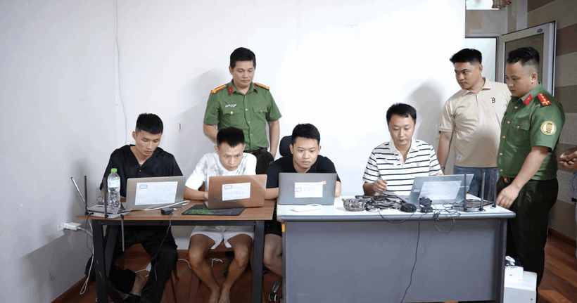 Lực lượng Công an kiểm tra căn nhà các đối tượng thuê làm nơi lưu trú và thực hiện hành vi lừa đảo trực tuyến; vật chứng thu giữ gồm nhiều máy tính xách tay và thiết bị điện tử liên quan. (Ảnh: Công an Lào Cai)