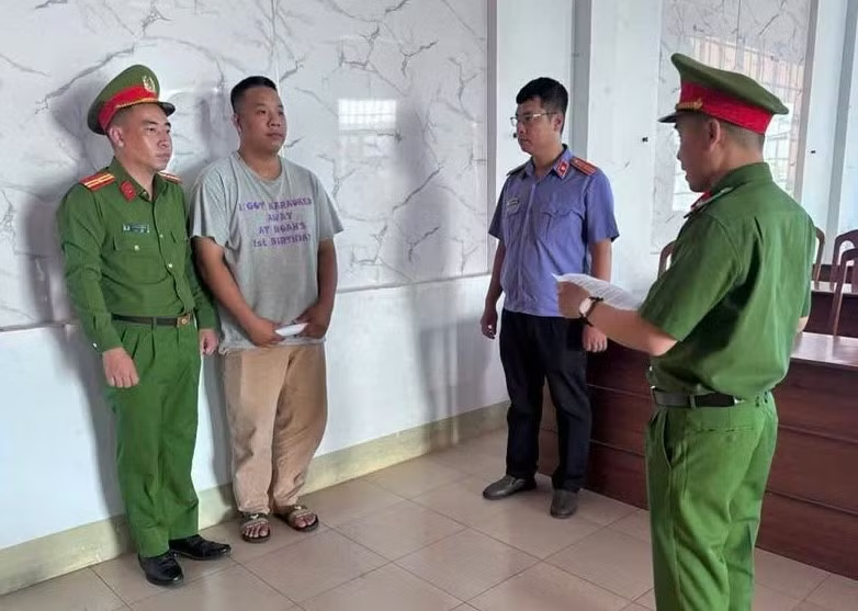 Cơ quan CSĐT Công an tỉnh Khánh Hòa đọc lệnh khởi tố Nguyễn Tấn Hiệp (thứ 2, bìa trái). Ảnh: Tiền Phong