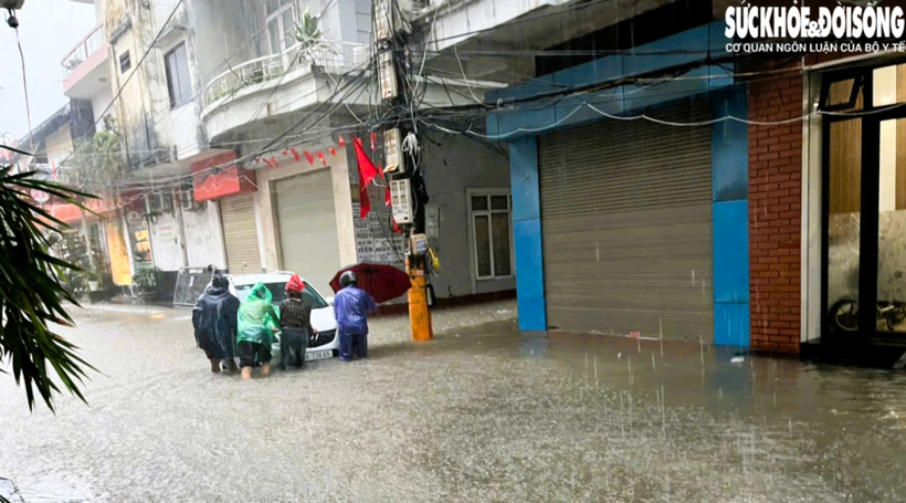 Phương tiện đang đi bị nước ngập gây chết máy được người dân hỗ trợ di chuyển ra khỏi chỗ sâu. Ảnh: CTV/ Theo Sức khỏe và Đời sống.