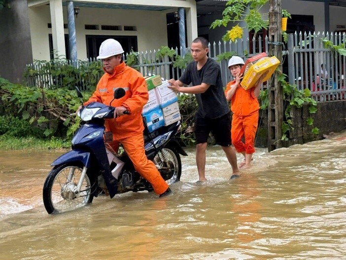 Nhân viên Công ty Điện lực Thái Nguyên hỗ trợ người dân di chuyển tài sản và nhắc nhở ngắt aptomat để bảo đảm an toàn khi mưa lũ đến