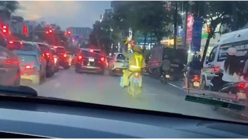 Trung tá Tạ Quang Hùng ra hiệu cho các phương tiện nhường đườn. (ảnh GĐ bệnh nhi chụp).
