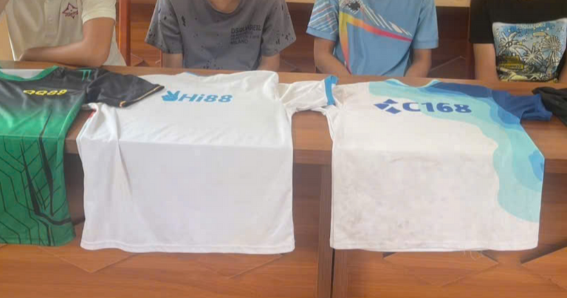 Áo phông có in hình logo các trang cờ bạc trực tuyến được các đối tượng tán phát cho học sinh dưới dạng quà tặng. (Ảnh: Bộ Công an)