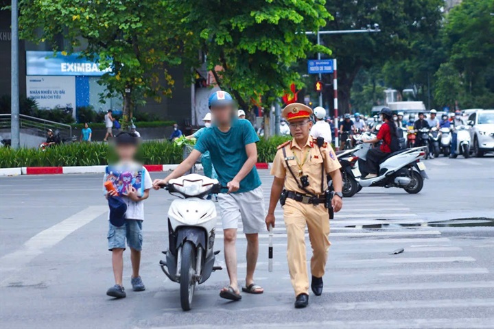 Trường hợp phụ huynh chở học sinh không đội mũ bảo hiểm cho con khi ngồi trên xe máy tham gia giao thông.