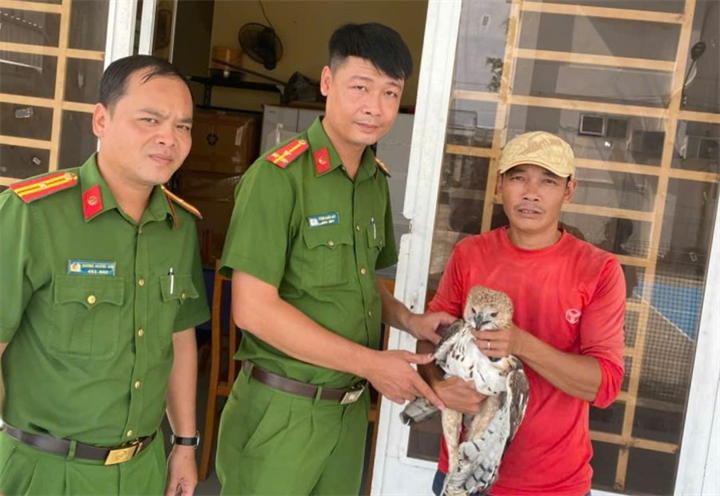 Anh Nguyễn Hữu Khánh giao nộp cá thể chim diều hoa Miến Điện cho Công an xã Khánh Bình. Ảnh: Công an An Giang