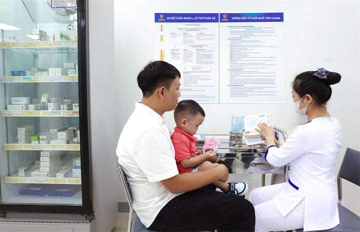 Anh Nguyễn Đức Quý đưa con trai Nguyễn Chí Minh Đức (23 tháng tuổi) đến VNVC tiêm vắc xin tay chân miệng ngay trong ngày đầu triển khai. Ảnh: Nhân Lê
