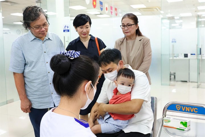 Bác sĩ Trương Hữu Khanh, người có hàng chục năm gắn bó với công tác điều trị các ca tay chân miệng nặng tại Việt Nam chứng kiến em bé đầu tiên tại Việt Nam tiêm vắc xin phòng tay chân miệng tại VNVC. Ảnh: Nhân Lê