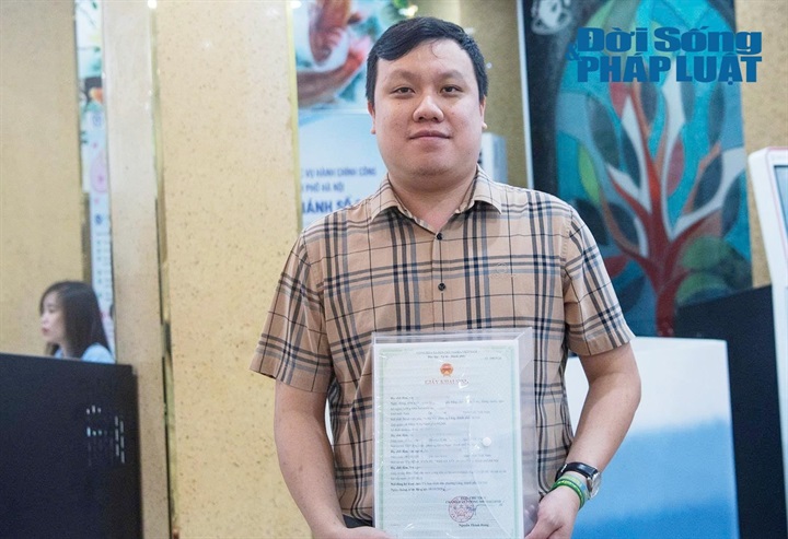 Anh Minh là một trong 2 người đầu tiên nhận giấy khai sinh cho con tại Bệnh viện Phụ sản Hà Nội trong ngày đầu triển khai thí điểm. Ảnh: Di Hân