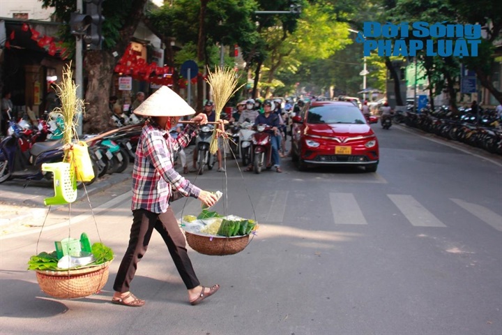 Hương vị thu Hà Nội không chỉ phảng phất trong không gian mà còn kết tinh nơi từng thức quà bình dị, từng ly cà phê vỉa hè. Trên khắp các nẻo đường, những gánh hàng rong lặng lẽ theo chân người bán len lỏi qua từng con ngõ, chở theo cả mùa thu trong hương cốm mới thân quen. (Ảnh: Khánh Phương)