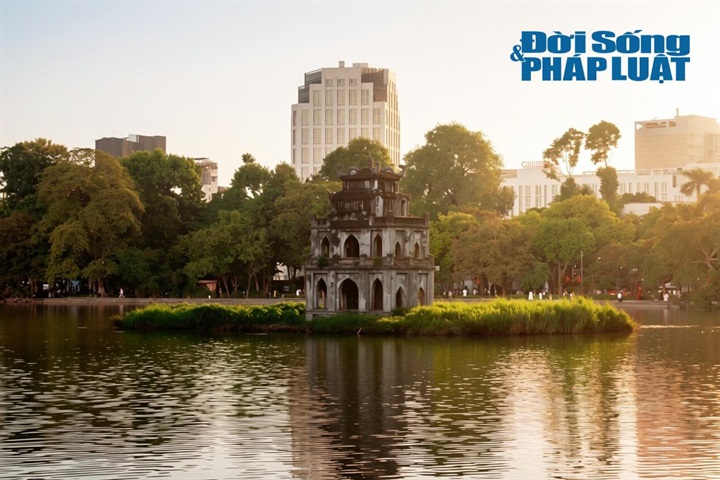 Chiều muộn, ánh hoàng hôn buông xuống nhuộm vàng mặt nước, soi bóng Tháp Rùa cổ kính tạo nên một bức tranh thủy mặc êm đềm. Trong khoảng không tĩnh lặng cuối ngày, nhịp sống phố phường như lắng đọng lại, mang đến cảm giác nhẹ nhõm, an yên cho mỗi bước chân dừng lại ngắm nhìn. (Ảnh: Khánh Phương)