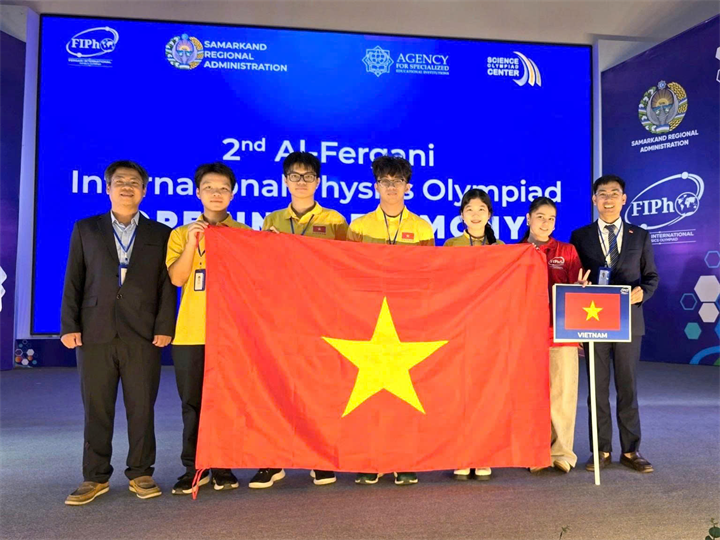 Đoàn học sinh Việt Nam tại FiPhO 2026 (Từ trái qua phải: PGS.TS Phạm Văn Hải, em Trương Bá Chí Thành, em Lê Bá Tuấn Việt, em Tăng Hạo Nhiên, em Lê Hồng Nhân, tình nguyện viên và PGS.TS Nguyễn Công Toản). Ảnh: Moet