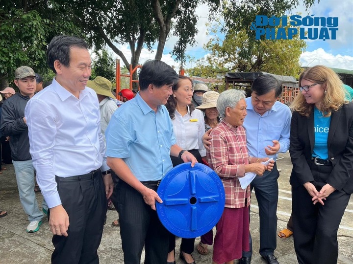 Thứ trưởng Bộ Nông nghiệp và Môi trường Nguyễn Hoàng Hiệp cùng lãnh đạo địa phương, UNICEF... đưa bồn chứa nước lên xe cho người dân. Ảnh: NVCC