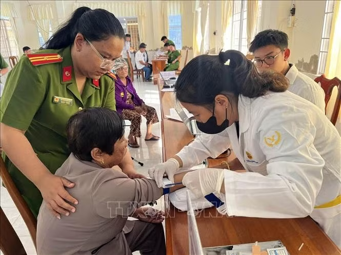 Cán bộ thu nhận sinh phẩm ADN thân nhân liệt sĩ chưa xác định danh tính. Ảnh: TTXVN phát