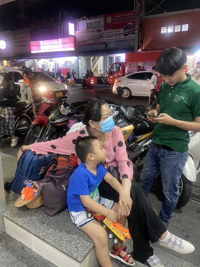 Bến xe miền Đông lúc này: Hành khách chạy đôn chạy đáo trong đêm tìm vé xe về quê, trẻ nhỏ mướt mải mồ hôi ngủ gục trên vai bố mẹ - Ảnh 4.