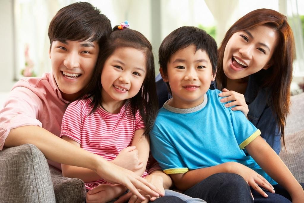 depositphotos24444839 stock photo chinese family relaxing on sofa