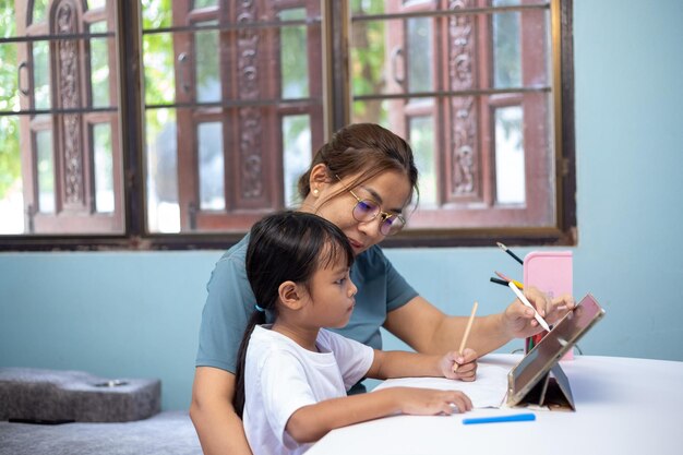 woman child are sitting table with tablet front them64894 648