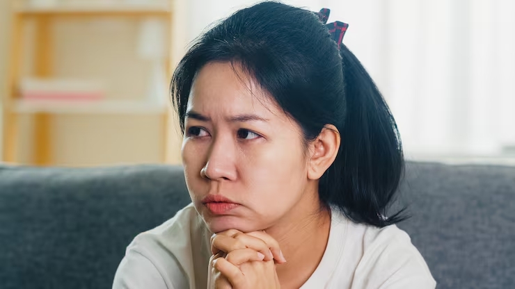depressed crying asian woman stressed with headache sitting sofa living room house7861 2455