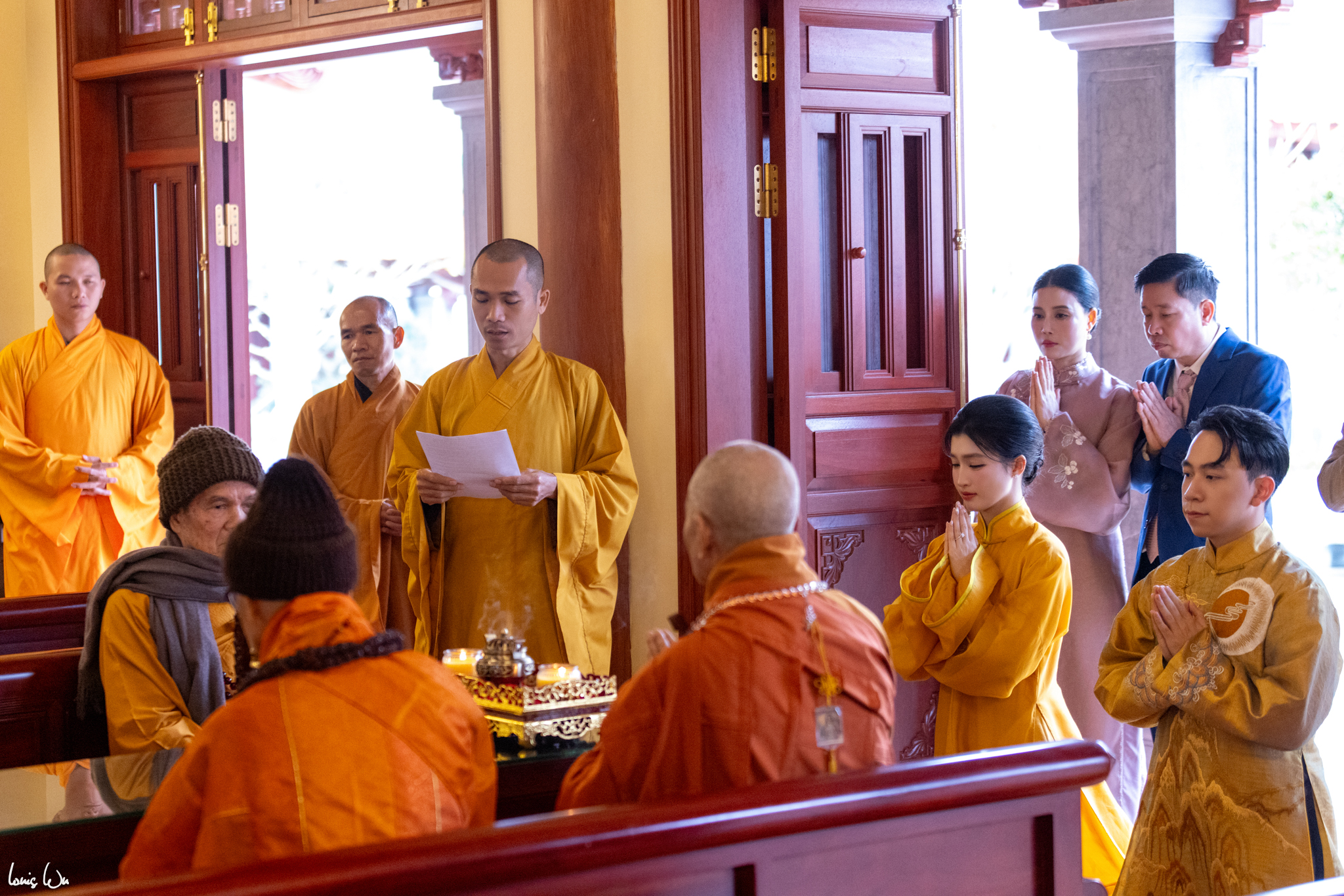 anh 6chu re va co dau mac co phuc viet mau vang dac trung cua phat giao kinh can lam le hang thuan o chua truc lam phung thuy son tren nui chin khuc khanh hoa phia sau la bo me co dau cung chung kien khoanh khac t