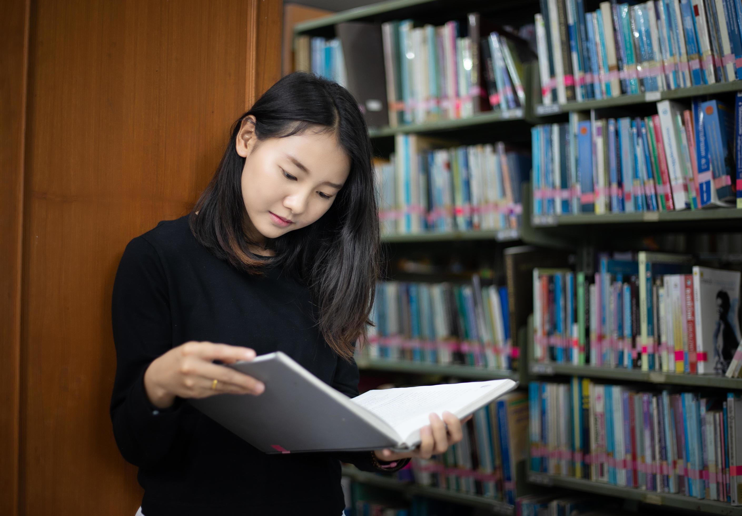 asian students reading books in the library free photo