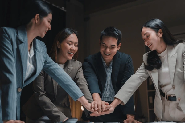 four cheerful asian businesspeople joining 600nw 2599487699