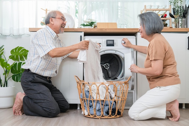 happy asian senior older man helping his wife put clothes washing machine laundry room34755 1258