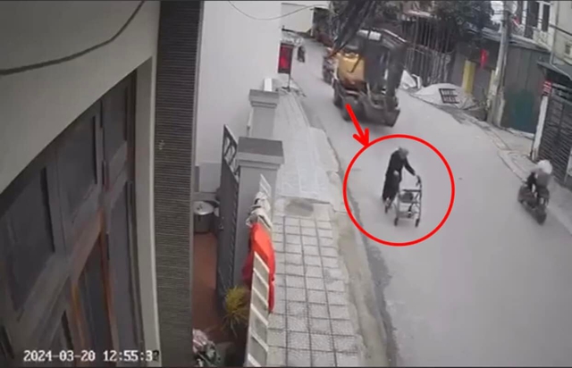 Cụ bà lưng còng bị máy xúc cán trực diện, đoạn camera 40 giây ghi lại khoảnh khắc va chạm thương tâm- Ảnh 1.