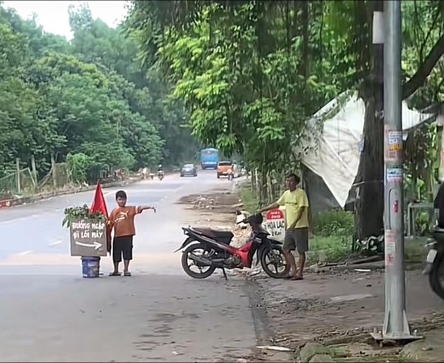 Tấm biển "lạ" giữa làn nước ngập ở đại lộ Thăng Long của 3 chú cháu: Đứng suốt 5 tiếng không thấy mỏi chân- Ảnh 2.