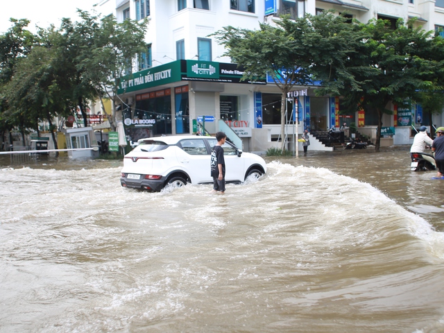 Trời hửng nắng, nhiều tuyến đường ở Hà Nội vẫn ngập sâu, người dân dùng tấm chắn để ngăn nước tràn vào nhà- Ảnh 12. Trời hửng nắng, nhiều tuyến đường ở Hà Nội vẫn ngập sâu, người dân dùng tấm chắn để ngăn nước tràn vào nhà- Ảnh 12.