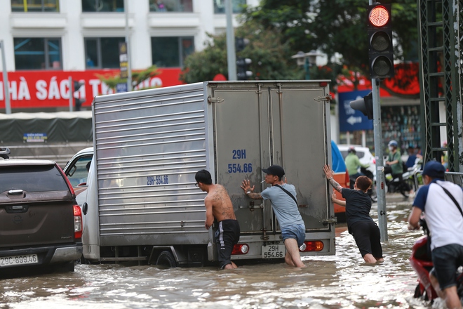 Trời hửng nắng, nhiều tuyến đường ở Hà Nội vẫn ngập sâu, người dân dùng tấm chắn để ngăn nước tràn vào nhà- Ảnh 15. Trời hửng nắng, nhiều tuyến đường ở Hà Nội vẫn ngập sâu, người dân dùng tấm chắn để ngăn nước tràn vào nhà- Ảnh 15.